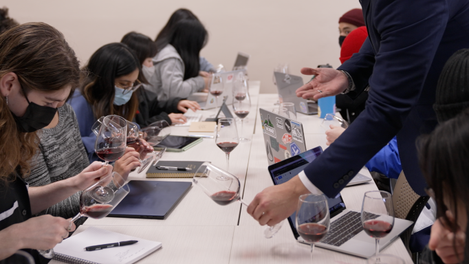 Professor showing hospitality students how to examine wine